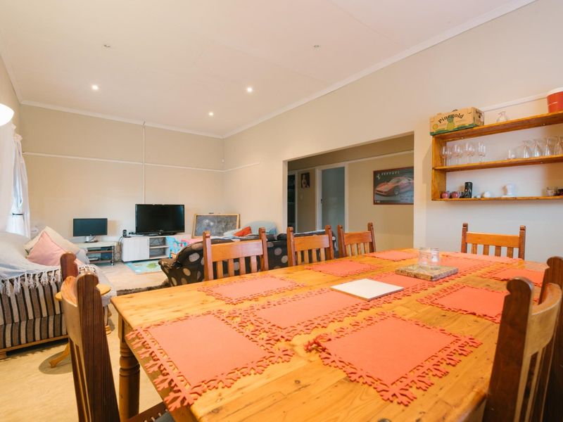 Open-plan living and dining area featuring recessed downlighting, coved ceilings, and built-in wall shelving, providing a functional and connected living space.