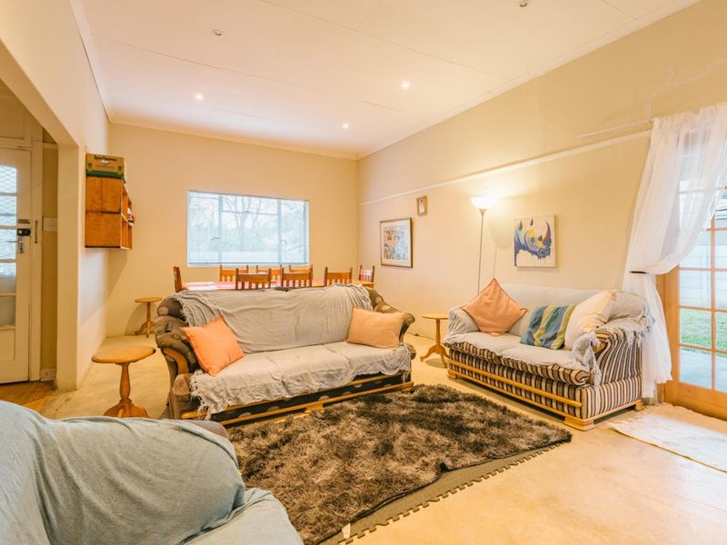Spacious open-plan living and dining area featuring recessed lighting, large windows, and direct access to the outdoor space through a sliding glass door.