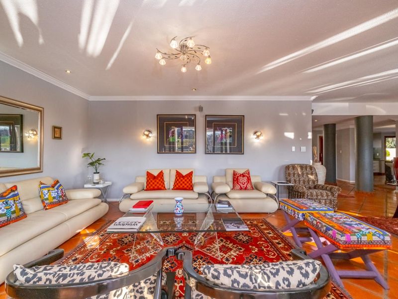 Spacious living room featuring terracotta floor tiles, recessed downlighting, and decorative wall sconces, creating a warm and inviting atmosphere.