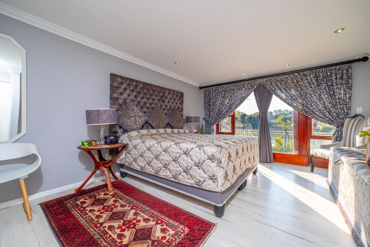 Spacious bedroom featuring tiled flooring, recessed lighting, crown molding, and large sliding glass doors providing natural light and access to the exterior.