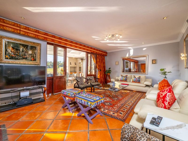 Spacious living room featuring terracotta floor tiles, recessed lighting, and large wooden sliding doors providing seamless access to the outdoor patio area.