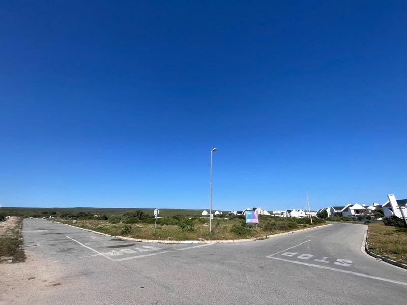 A street-level view of the intersection adjacent to the vacant residential land, featuring paved roads, street lighting, and established neighborhood infrastructure.