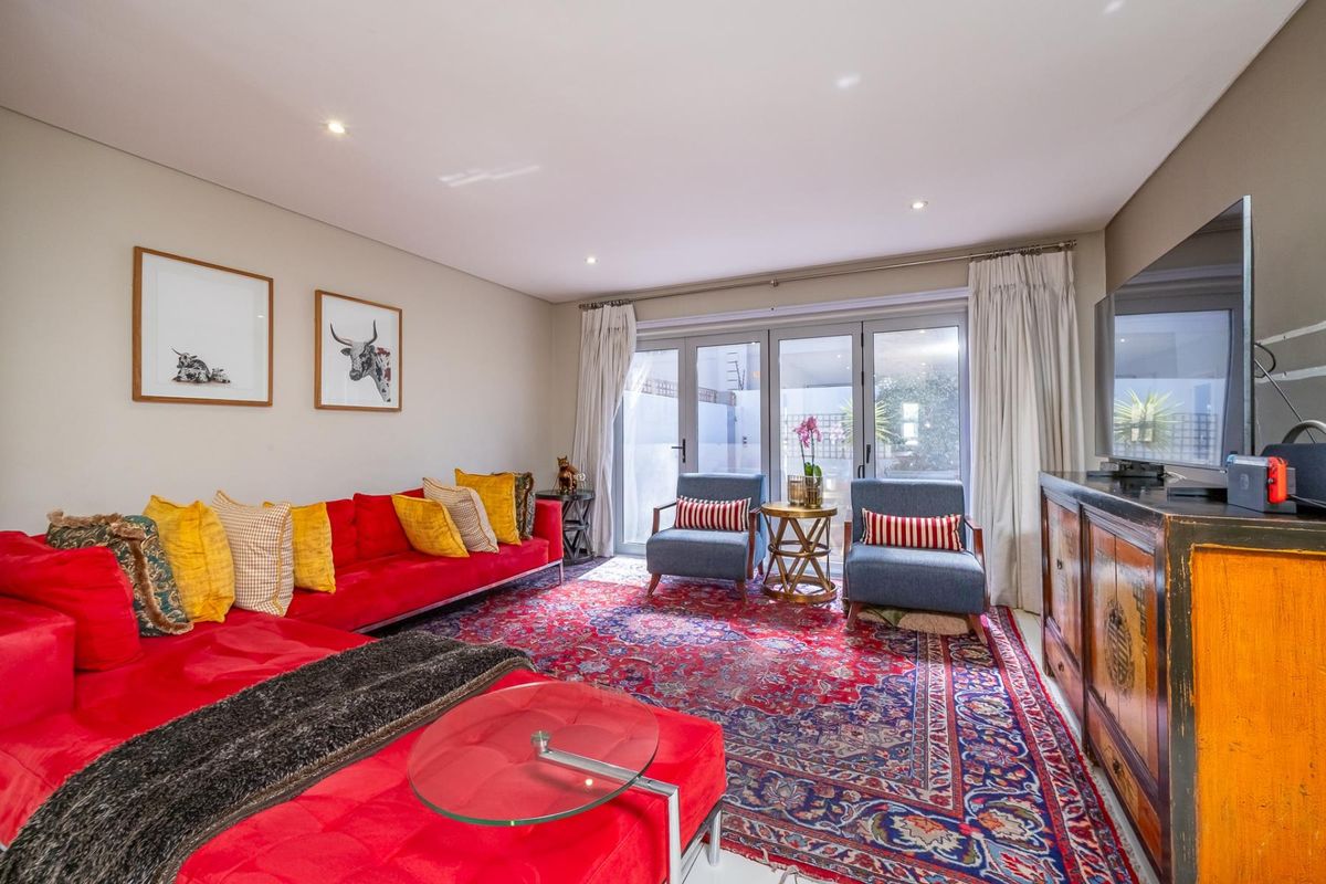 Spacious living room featuring recessed downlighting and large aluminium-framed glass sliding doors providing direct access to the outdoor area.