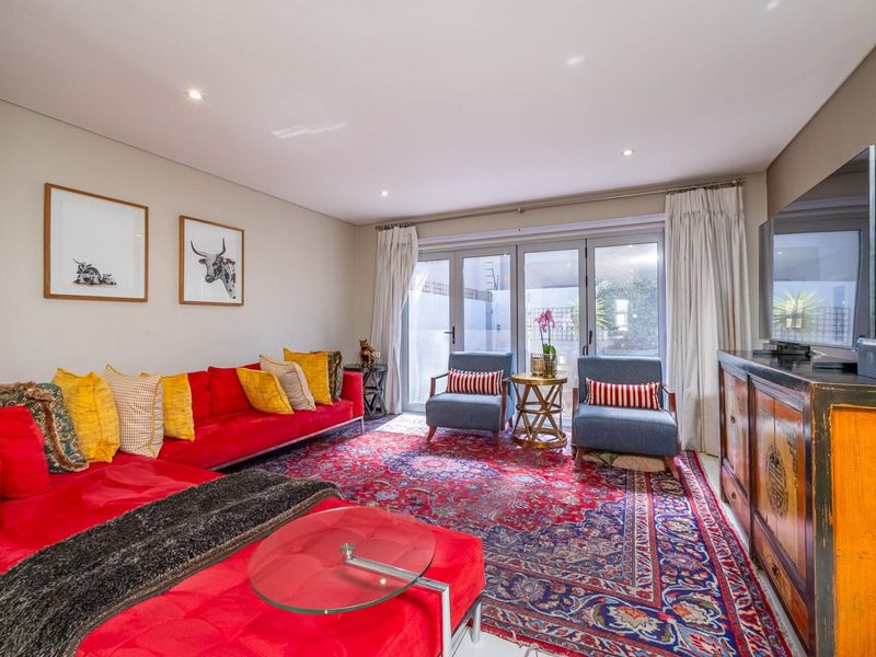 Spacious living room featuring recessed downlighting and large aluminium-framed glass sliding doors providing direct access to the outdoor area.