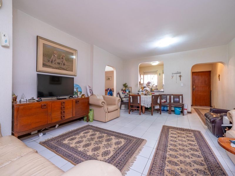 Open-plan living and dining area featuring tiled flooring and arched transitions between spaces, providing a functional layout for daily living.