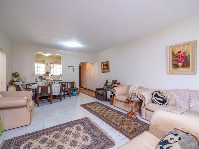 Open plan living and dining area featuring tiled flooring and arched architectural transitions between spaces.