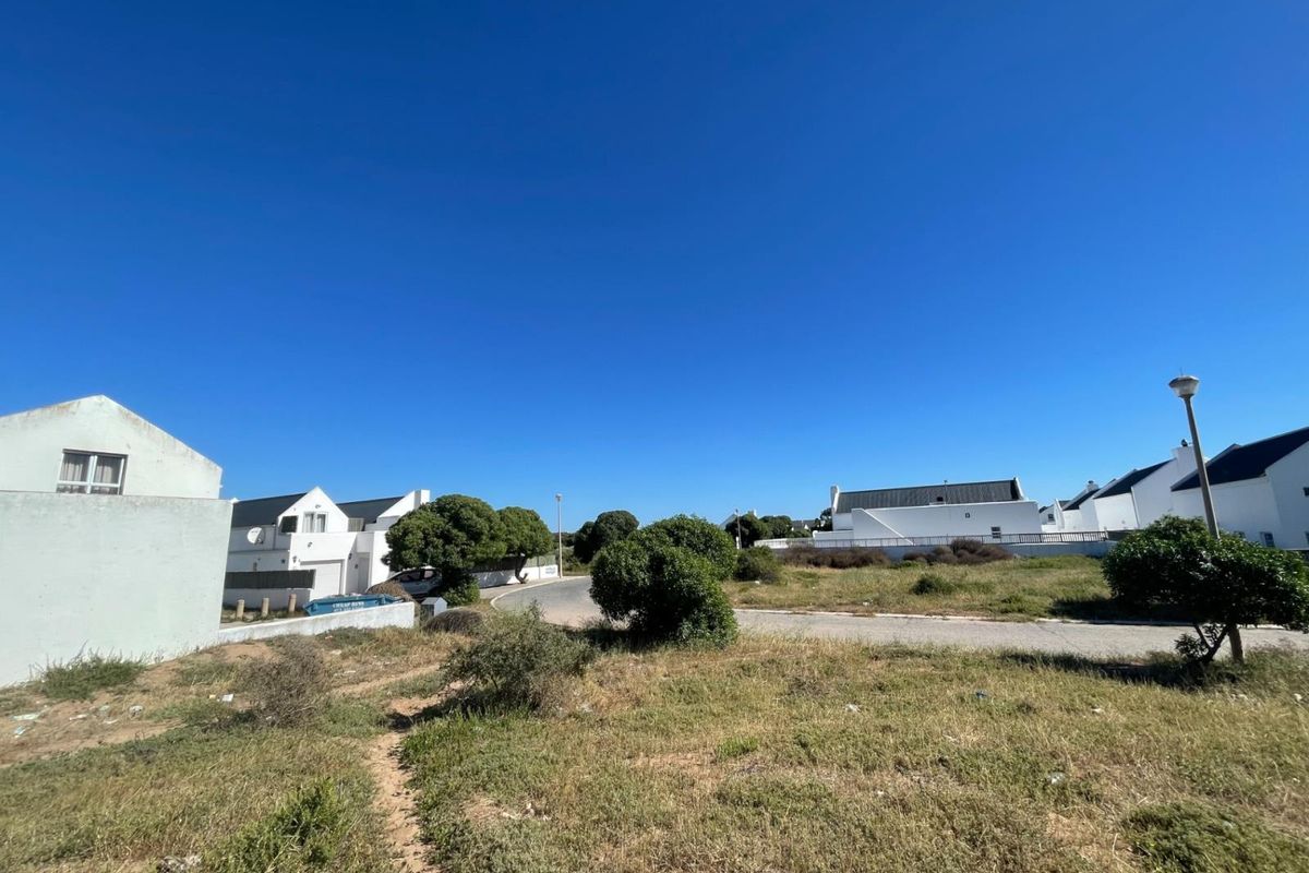 A street view showing the surrounding residential neighborhood with paved roads and established housing in a coastal estate setting.