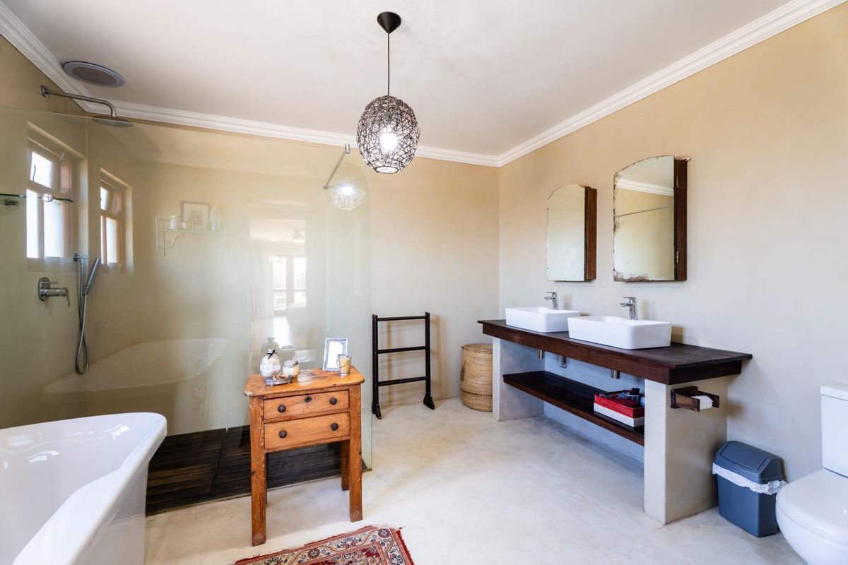 Spacious bathroom featuring a double vanity with vessel sinks, a large walk-in shower with glass screen, and a freestanding bathtub.