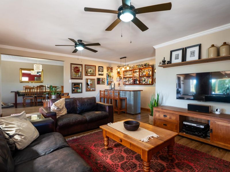 Spacious open-plan living area featuring a built-in bar, ceiling fans, and seamless flow into the adjacent dining space.