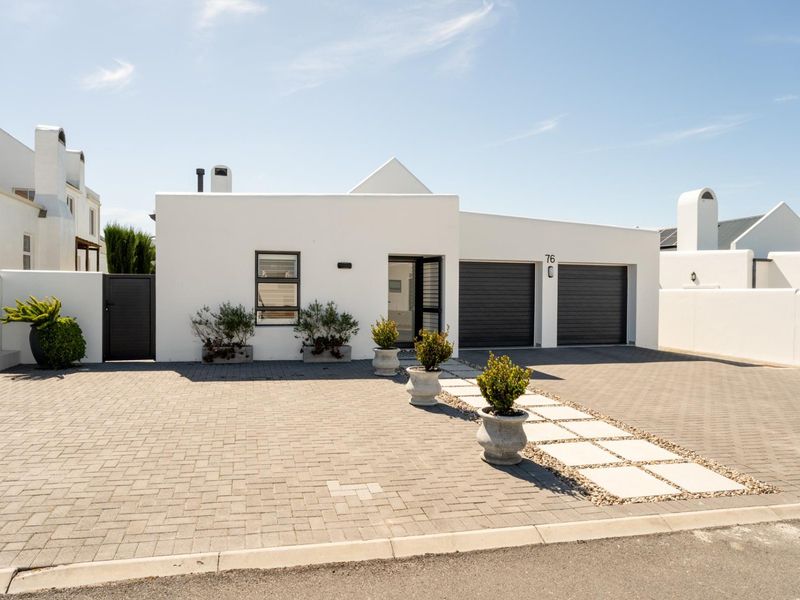 Modern front elevation featuring a double garage, paved driveway, and clean white facade with contemporary architectural lines.