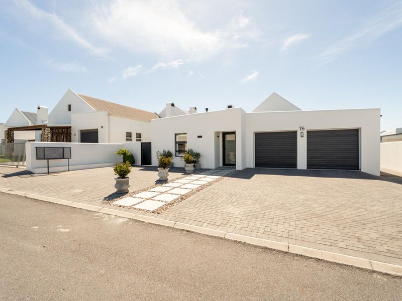 Modern front elevation featuring a double garage, paved driveway, and clean white architectural lines.