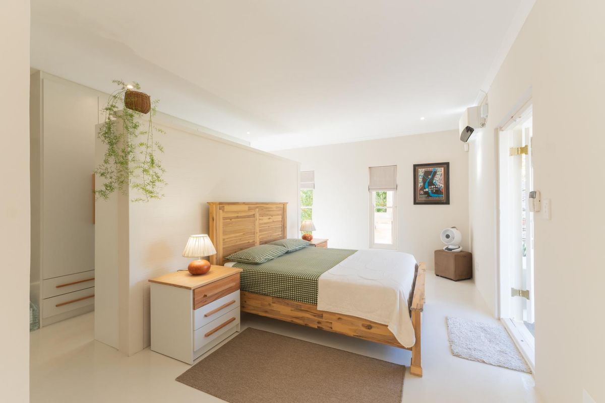 Spacious bedroom featuring a built-in partition wall, ample cupboard space, and a split-system air conditioner with direct access to the exterior.
