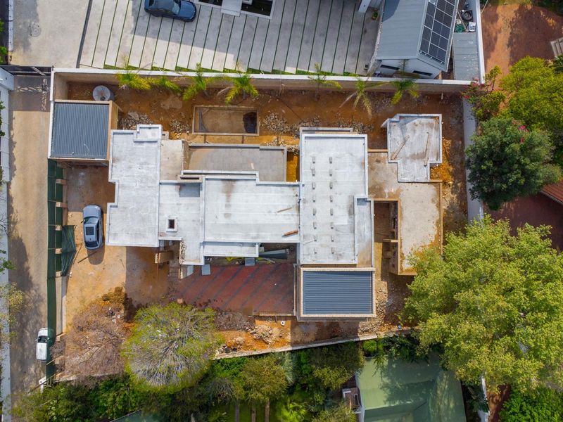 Aerial view of a residential property currently under construction, showing the building footprint, concrete roof slabs, and surrounding site development.
