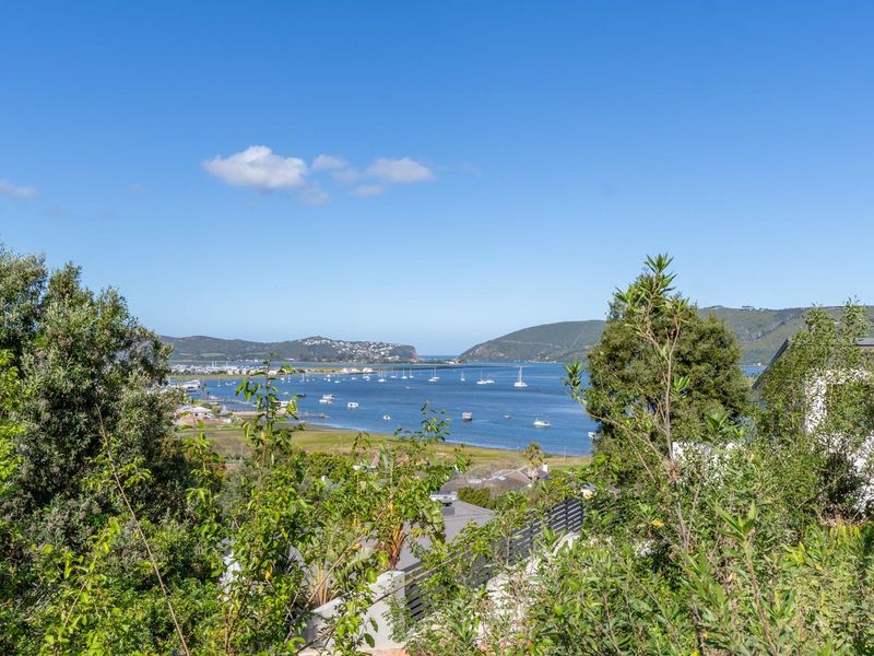 A scenic elevated view overlooking the estuary, surrounding hills, and distant coastal landscape.