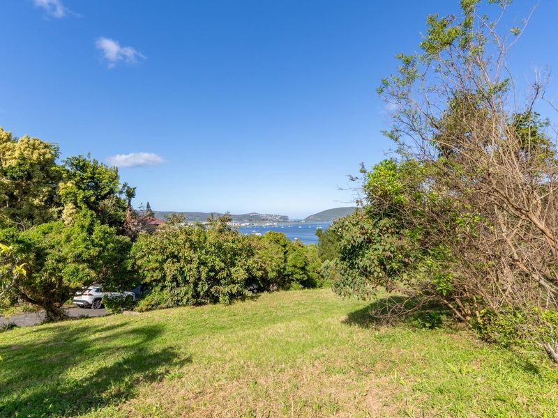 A scenic view of the coastal landscape and bay, captured from the elevated, grassed residential land.