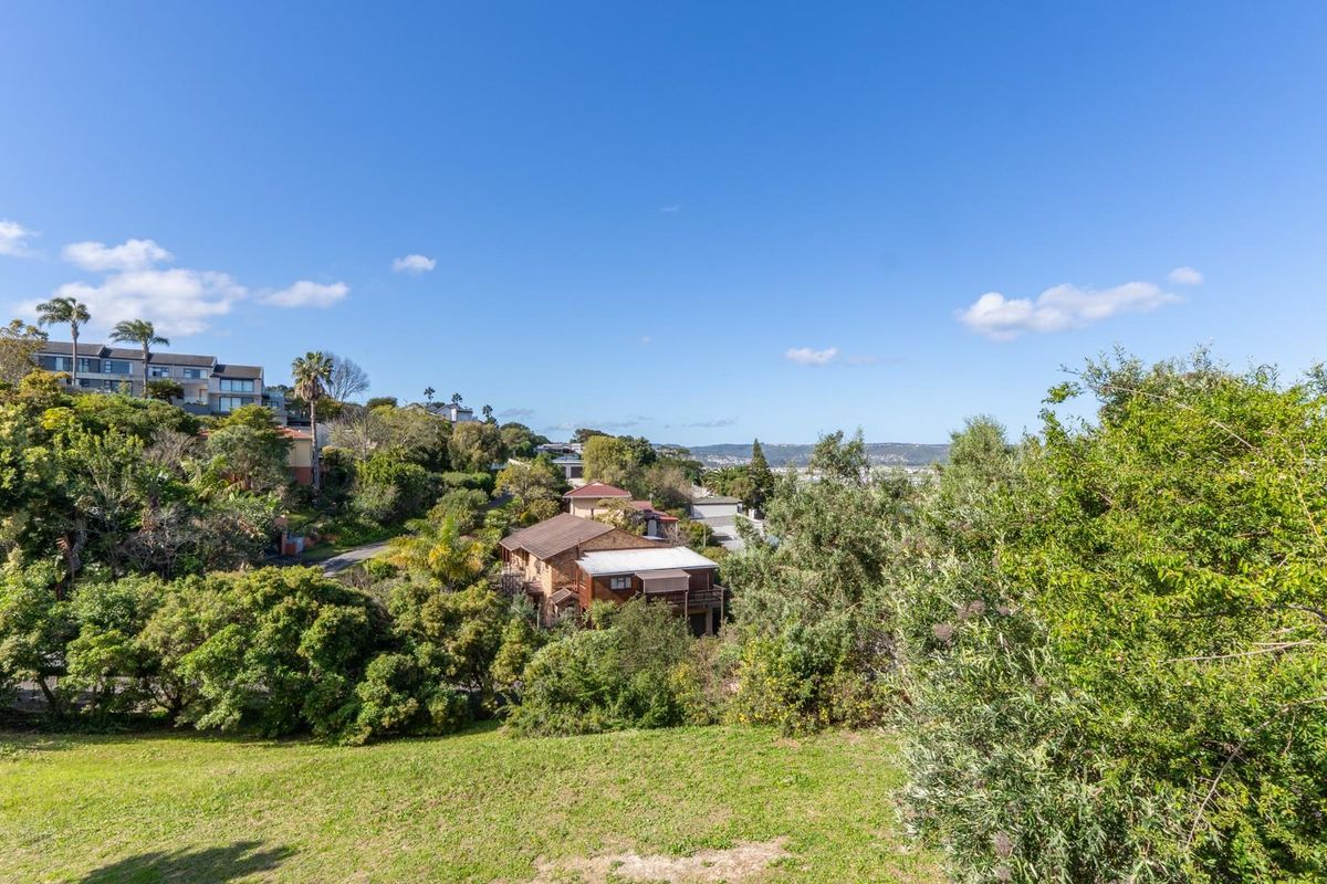 A scenic elevated view overlooking the surrounding residential neighbourhood and lush green landscape, showcasing the natural topography of the vacant land.