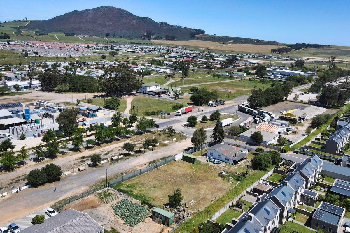 Aerial view of a commercial land parcel situated within a mixed-use area, featuring surrounding infrastructure and road access.