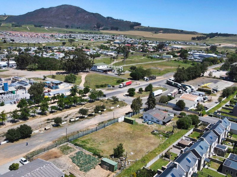 Aerial view of a commercial land parcel situated within a mixed-use area, featuring surrounding infrastructure and road access.
