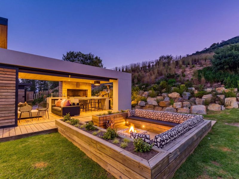 Modern covered patio featuring a built-in braai area and a sunken fire pit set within a beautifully landscaped garden.