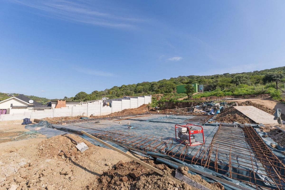 A construction site showing a prepared foundation slab with reinforcing steel mesh, ready for the next phase of building development.