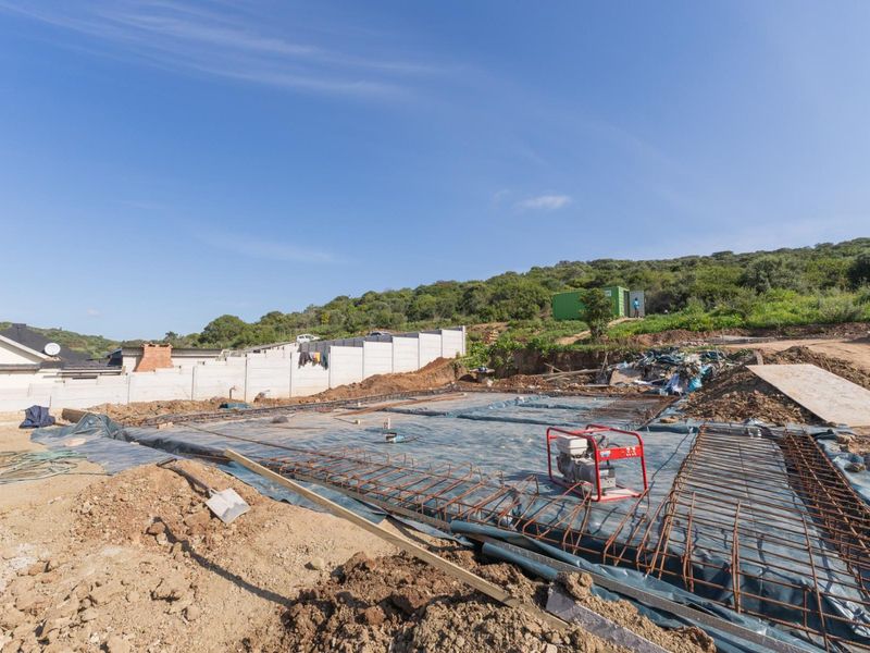 A construction site showing a prepared foundation slab with reinforcing steel mesh, ready for the next phase of building development.