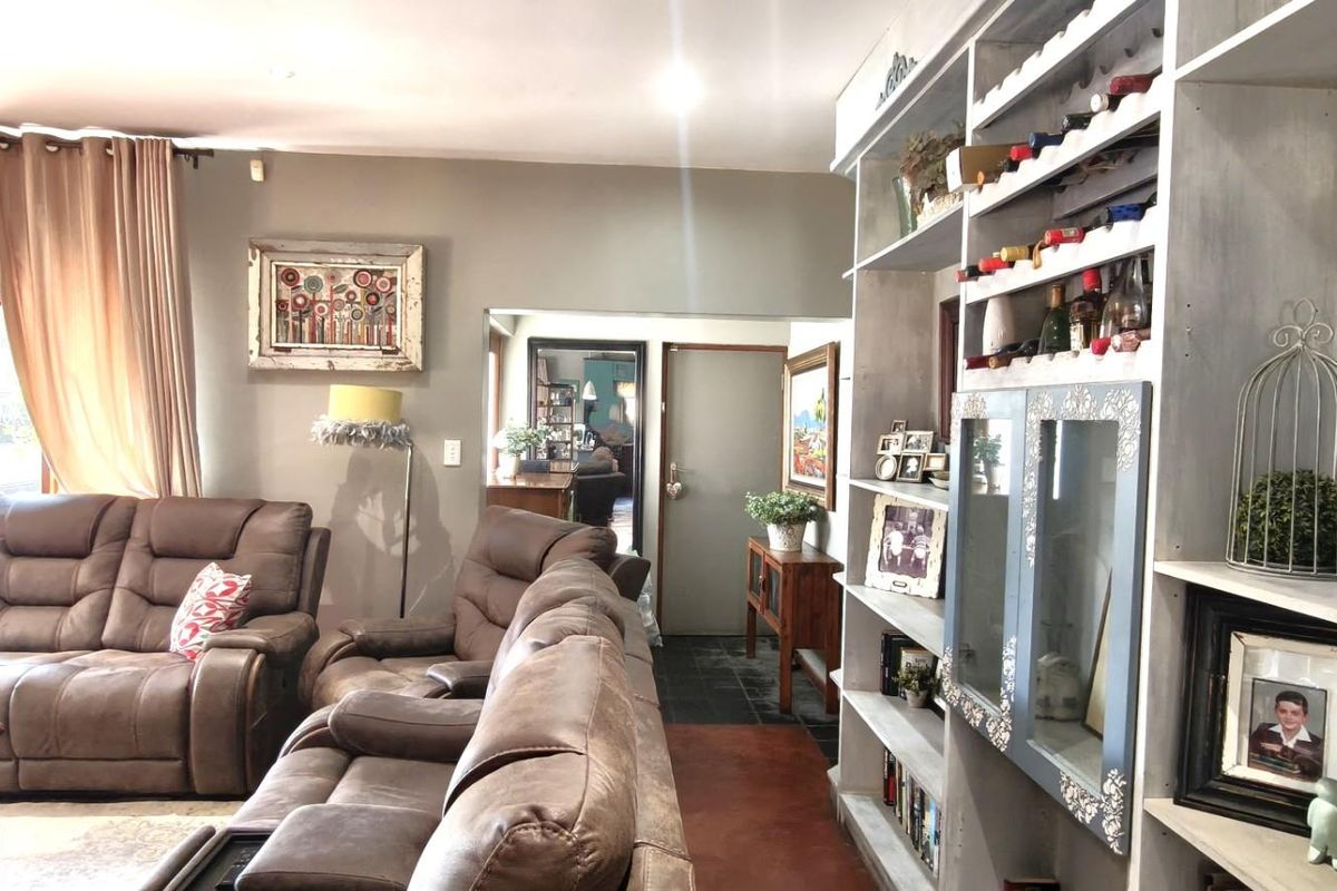 A comfortable living room featuring a large built-in shelving unit with integrated wine storage and neutral wall finishes.