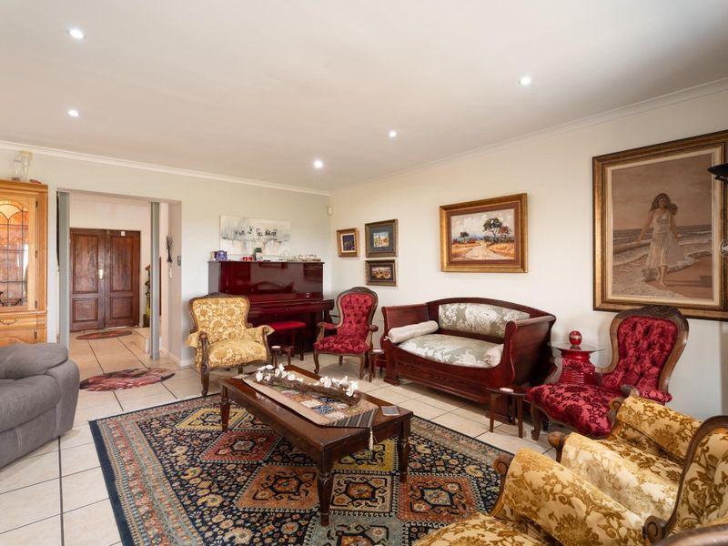 Spacious living room featuring tiled flooring, recessed downlights, and coved ceilings, providing a comfortable and well-maintained area for relaxation.