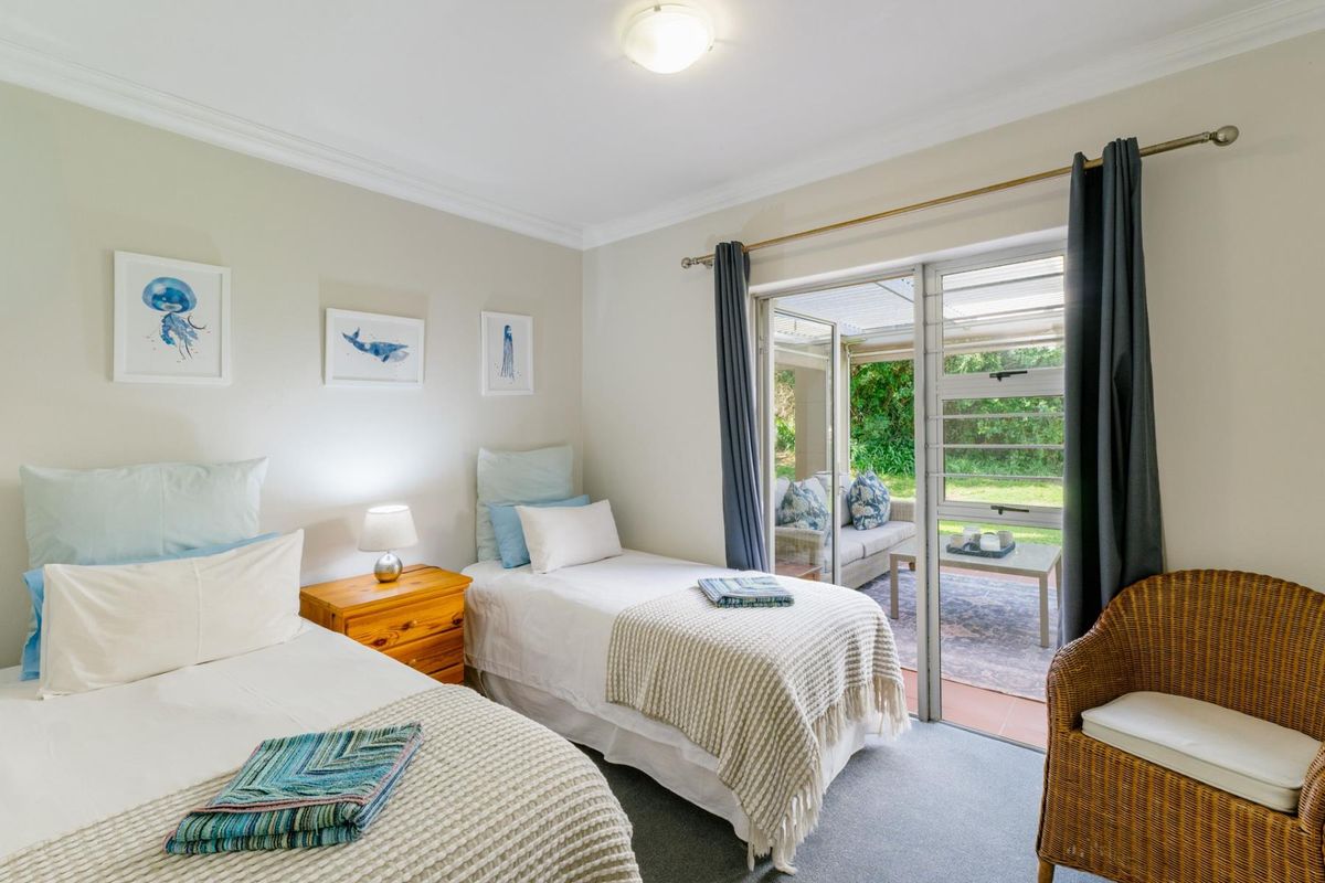 A well-lit bedroom featuring neutral walls, carpet flooring, and a sliding glass door providing direct access to an outdoor patio area.