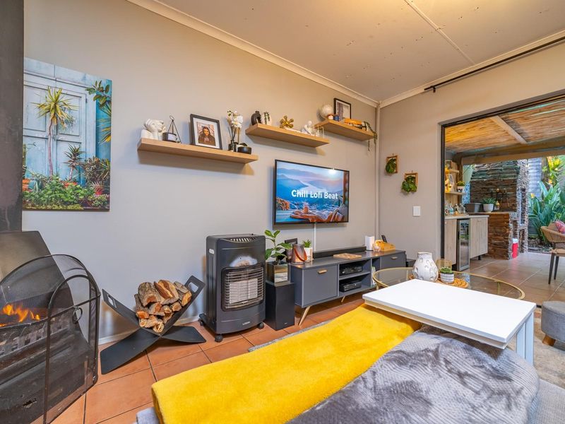 Cozy living room featuring a freestanding fireplace, tiled flooring, and direct access to an outdoor patio area.