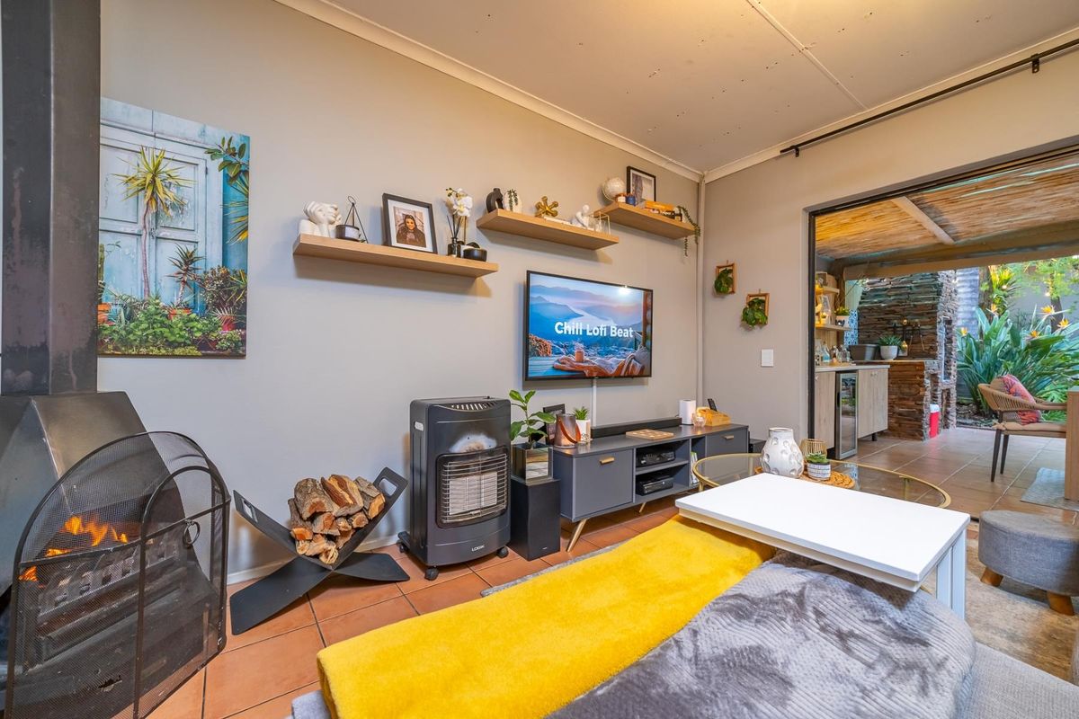 Cozy living room featuring a freestanding fireplace, tiled flooring, and direct access to an outdoor patio area.