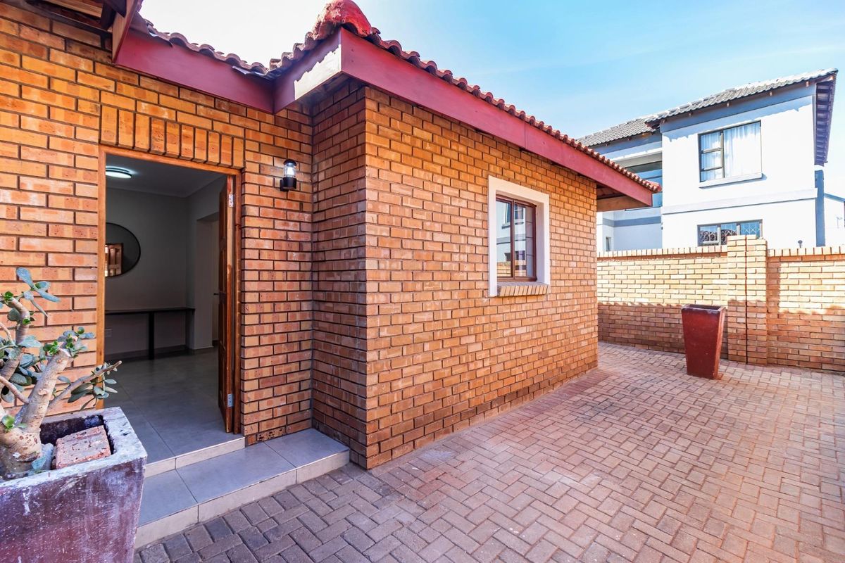 A private rear courtyard featuring face brick exterior walls, a tiled roof, and paved flooring, providing a low-maintenance outdoor space.