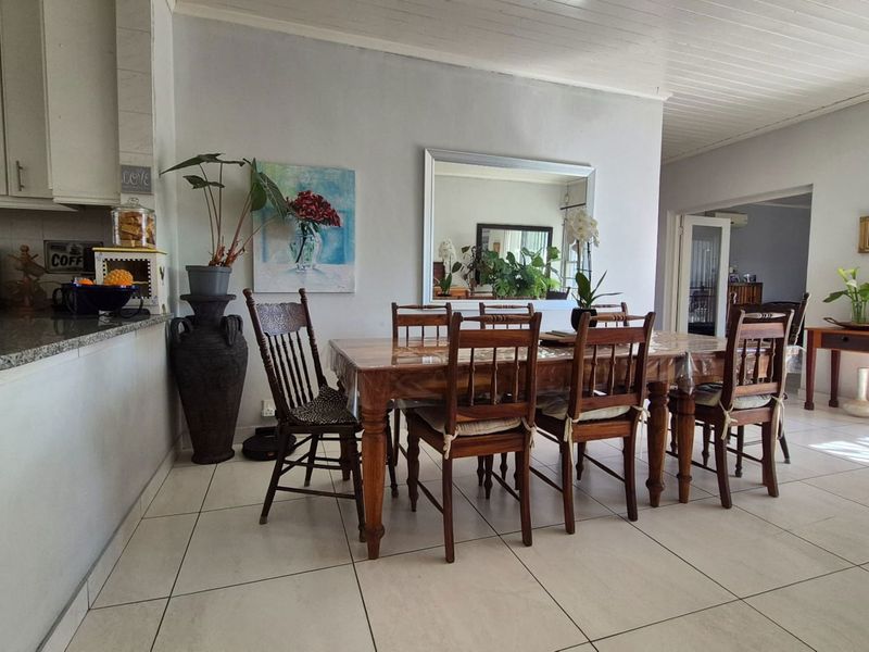 Open plan kitchen and dining area featuring tiled flooring, granite countertops, and a tongue and groove ceiling, providing a functional living space.