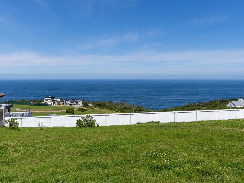 A vacant residential plot offering expansive, unobstructed ocean views and a clear coastal horizon.