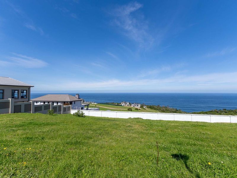 A vacant residential plot offering expansive, unobstructed ocean views and a well-maintained grassy landscape.