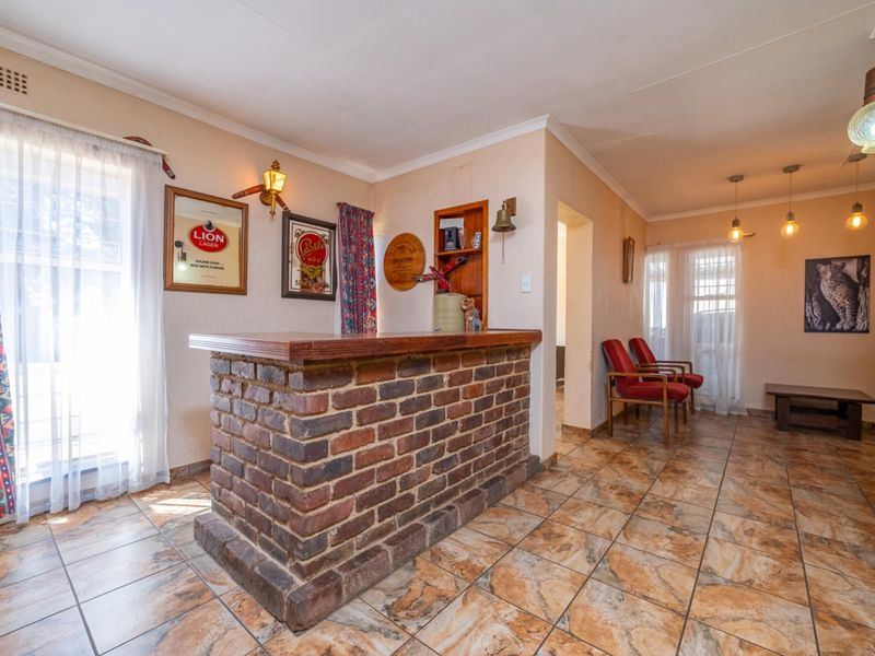 A dedicated bar area featuring a rustic brick-built counter, tiled flooring, and warm ambient lighting, offering a classic entertainment space.