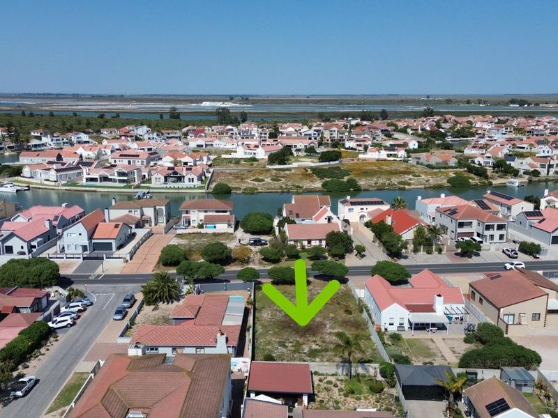 Aerial view of a vacant residential plot situated in a developed coastal estate, highlighting the available land and surrounding neighborhood infrastructure.