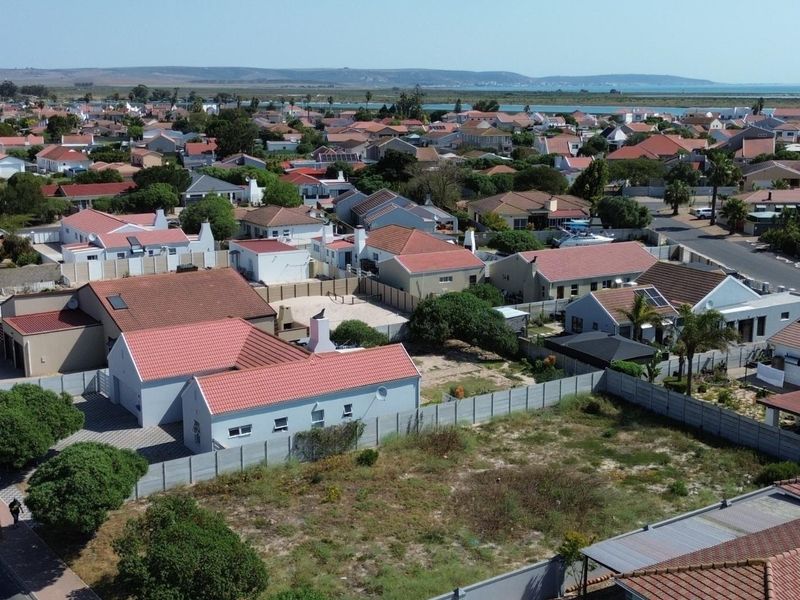 Aerial view of a vacant residential plot situated within an established suburban neighborhood, offering potential for new development.