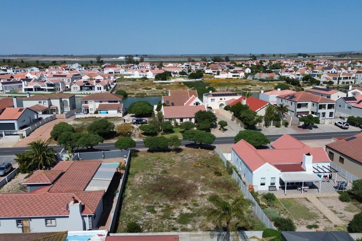 Aerial view of a vacant residential plot situated within an established suburban neighborhood, offering potential for new development.