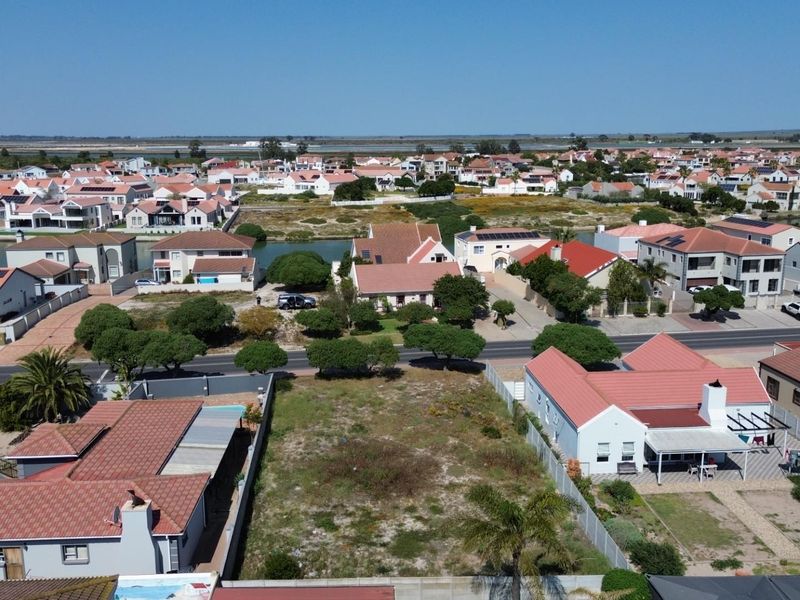 Aerial view of a vacant residential plot situated within an established suburban neighborhood, offering potential for new development.