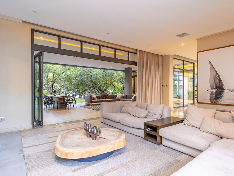 Spacious open-plan living area featuring large bi-fold glass doors that seamlessly connect the interior to the outdoor patio and garden.