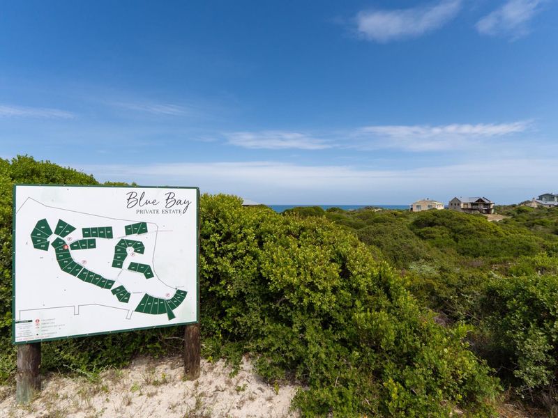 A clear site map signage for Blue Bay Private Estate, showcasing the layout of the residential development amidst natural coastal vegetation.