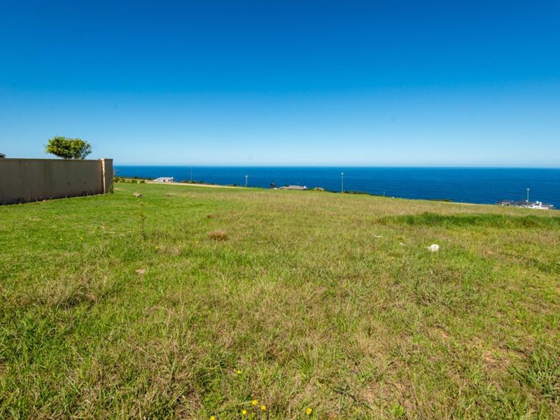 A vacant residential plot featuring expansive, unobstructed ocean views and a clear coastal horizon.