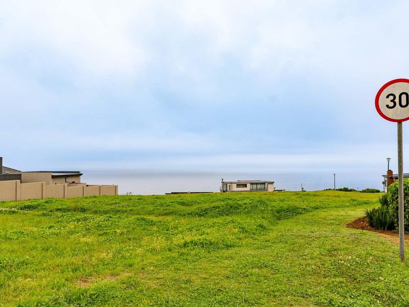 A vacant residential plot featuring expansive ocean views and natural grassland terrain, offering a prime opportunity for coastal development.