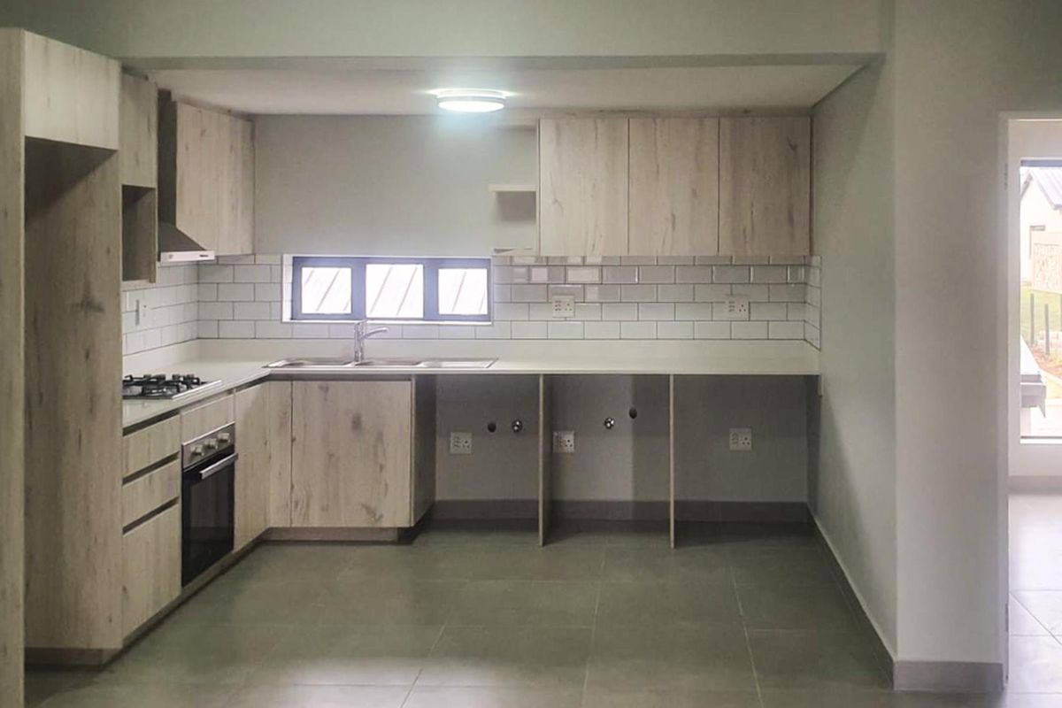 Modern kitchen featuring light wood-look cabinetry, subway tile backsplash, integrated oven, gas hob, and dedicated under-counter space for appliances.
