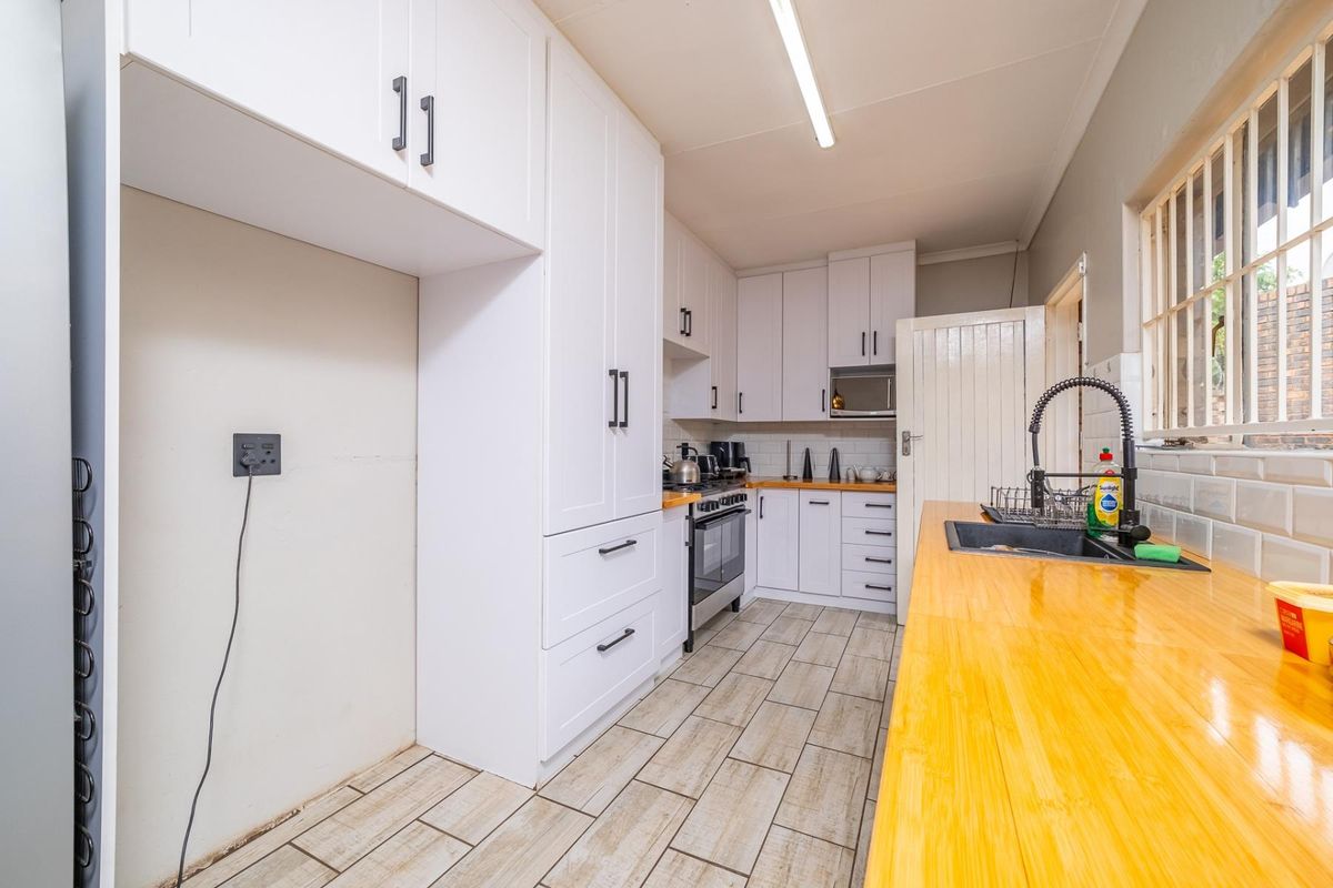 A modern kitchen featuring white cabinetry, wooden countertops, a gas stove, and a subway tile backsplash with a functional layout.