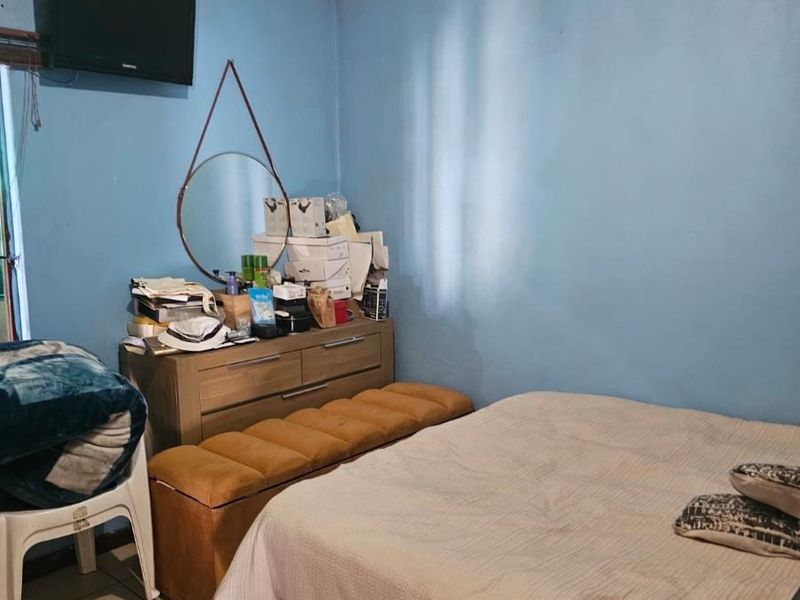 A bedroom featuring tiled flooring and blue painted walls, currently requiring ceiling maintenance and cosmetic updates.