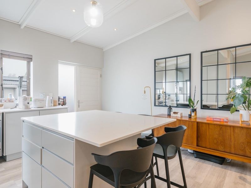 Modern kitchen featuring a central island with quartz countertops, gas stove, integrated extractor fan, and clean, contemporary cabinetry.