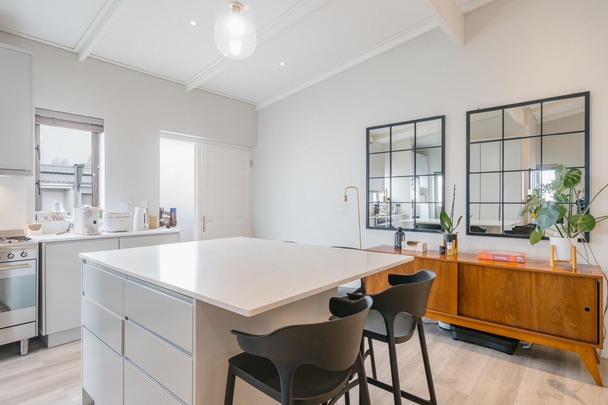 Modern kitchen featuring a central island with quartz countertops, gas stove, integrated extractor fan, and clean, contemporary cabinetry.