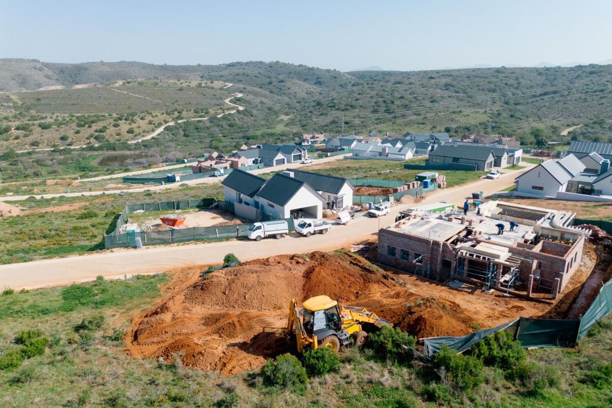 Aerial view of a residential development site showing ongoing construction, earthworks, and surrounding landscape in a developing estate.