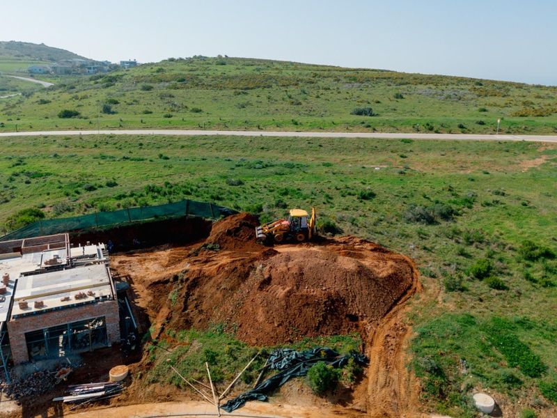 Aerial view of a residential vacant land plot currently undergoing active excavation and construction work.
